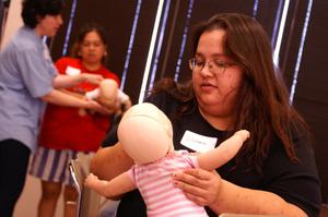 [Mothers use dolls to help in first aid training]
