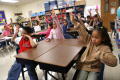 Photograph: [Students raise their hands in a Crockett Elementary class]