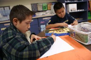 [Two boys work on their art projects at Crockett Elementary]