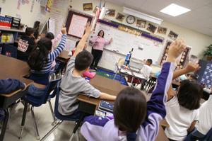 [Students raise their hands during a class at Crockett Elementary School]