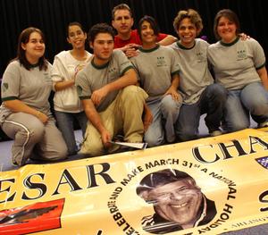 Primary view of object titled '[Students pose in front of a banner promoting a Cesar Chavez Day]'.