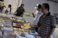 Thumbnail image of item number 1 in: '[People browsing stacks of books on tables]'.