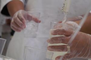 Primary view of object titled '[Close-up of gloved hands with lemonade pouring into cups]'.