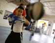 Photograph: [Young boy in boxing gloves hitting speed bag]