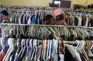 [People look through the clothing at Dallas Catholic Charities]