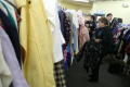 Primary view of [Woman and two men search for clothing at the Dallas Catholic Charities]